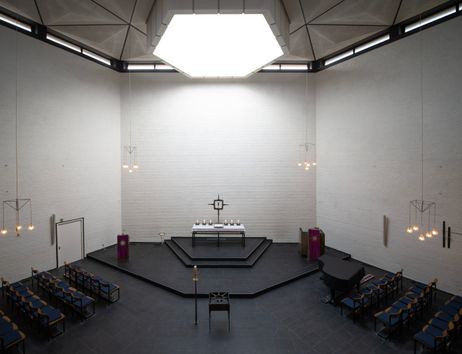 Innenansicht der Ansgarkirche mit Altar und Sitzreihen.