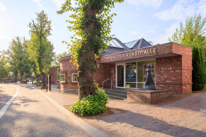 Außenansicht der Worpsweder Kunsthalle mit einer Skulptur vor dem Eingang.
