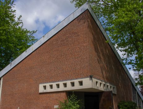 Backsteingebäude mit modernem Design und Bäumen im Hintergrund.