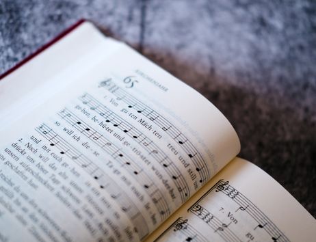 Nahaufnahme eines aufgeschlagenen Gesangbuchs mit Noten und Text des Liedes 'Von guten Mächten'.
