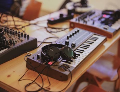 Kopfhörer liegen auf einem Synthesizer 