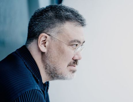 Ein Mann mit Brille und Bart schaut nach rechts. Er trägt ein dunkles Hemd und hat kurzes, graues Haar.