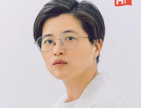 Porträt einer Person mit Brille und kurzem Haar vor einem weißen Hintergrund.
