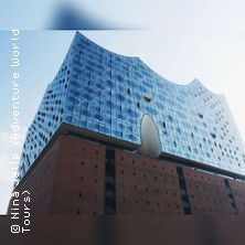 Außenansicht der Elbphilharmonie in Hamburg mit blauem Himmel im Hintergrund.