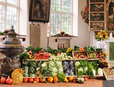 Erntedankfest in einer Kirche mit Gemüse und Obst dekoriert.