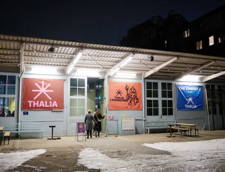 Eingang des Thalia Theaters in der Gaußstraße bei Nacht mit beleuchteten Bannern und schneebedecktem Boden.