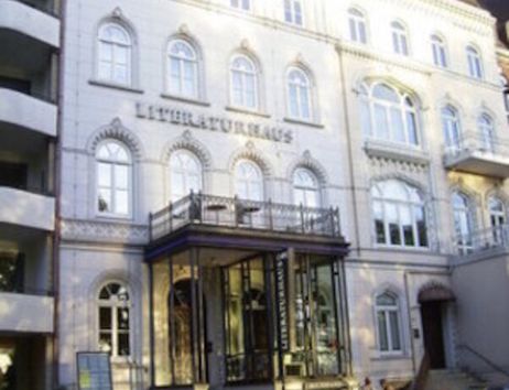 Fassade des Literaturhauses mit geparkten Autos davor.