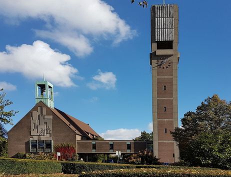 Außenansicht der Christus-Kirche mit Glockenturm und blauen Himmel.