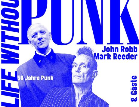 Zwei Männer in Anzügen vor einem großen Schriftzug 'PUNK'.