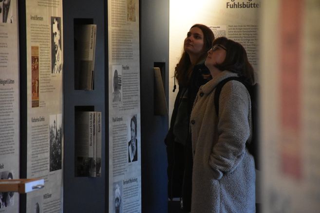 Zwei Menschen lesen Infotafeln in der Ausstellung