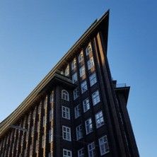 Spitzwinkliges Backsteingebäude im Kontorhausviertel vor blauem Himmel.