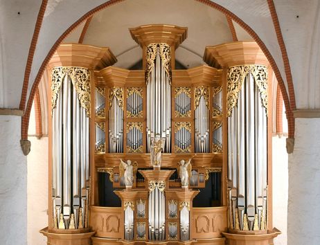 Eine prächtige Orgel mit goldenen Verzierungen und großen Pfeifen in einer Kirche.