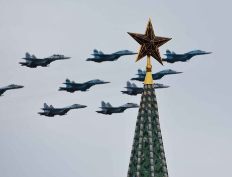 Kampfjets am Himmel, im Vordergrund die Spitze eines Turms auf der ein goldener Stern steht.