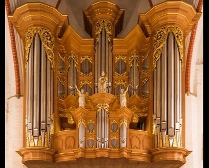 Nahaufnahme einer prunkvollen Orgel mit goldenen Verzierungen und Pfeifen.