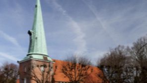 Kirche St. Johannis in Hamburg-Eppendorf mit grünem Turm und rotem Dach.
