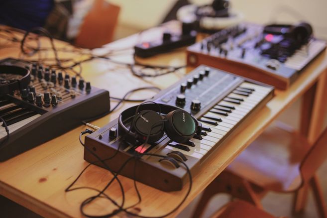 Kopfhörer liegen auf einem Synthesizer 
