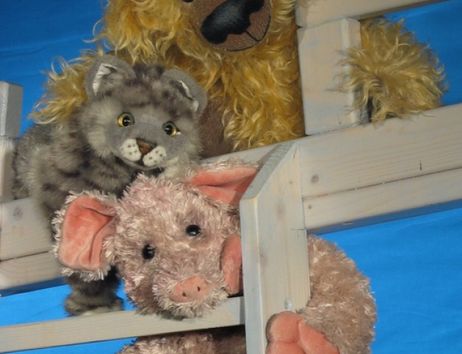 Man sieht den Rand von einem Hochbett, auf dem Kuschelbär-, -katze und -schwein sitzen.