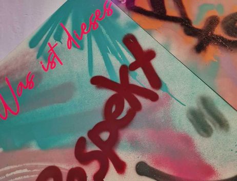 Graffiti mit den Worten 'Was ist dieses Respekt' in bunten Farben.