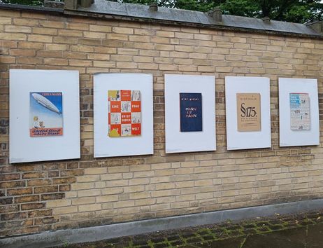 Plakate von Buchcovern an einer Backsteinmauer, Teil einer Ausstellung über Bücherverbrennungen 1933.
