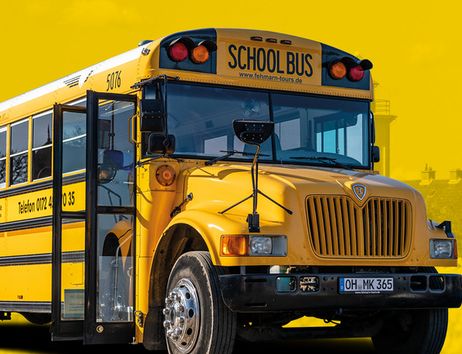 Gelber amerikanischer Schulbus mit offener Tür vor gelbem Hintergrund.