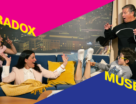 Eine Familie sitzt auf einem Sofa im Paradox Museum Hamburg, umgeben von optischen Täuschungen.