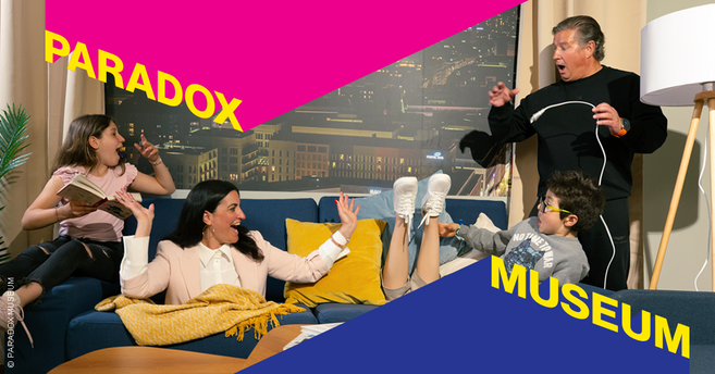 Eine Familie sitzt auf einem Sofa im Paradox Museum Hamburg, umgeben von optischen Täuschungen.
