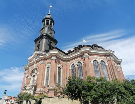 Die Kirche St. Michaelis in Hamburg mit ihrem markanten Turm und blauen Himmel im Hintergrund.