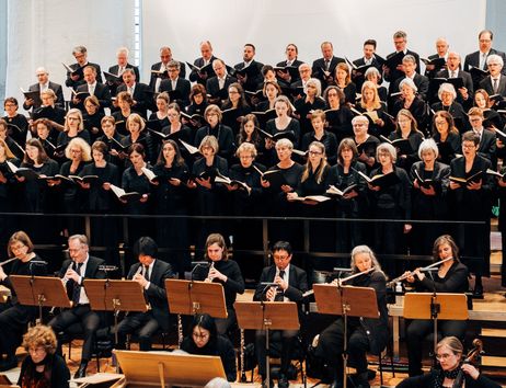 Ein Chor und ein Orchester führen gemeinsam ein Konzert auf.