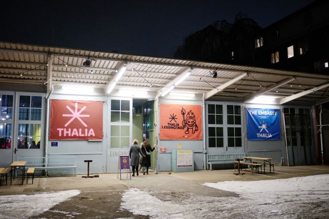 Eingang des Thalia Theaters in der Gaußstraße bei Nacht mit beleuchteten Bannern und schneebedecktem Boden.