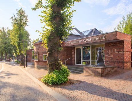 Außenansicht der Worpsweder Kunsthalle mit einer Skulptur vor dem Eingang.
