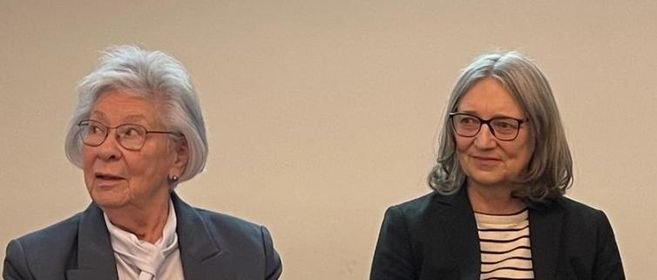 Margitta Sünwoldt und Claudia Vollmer gemeinsam auf einem Podium bei einer Veranstaltung. 