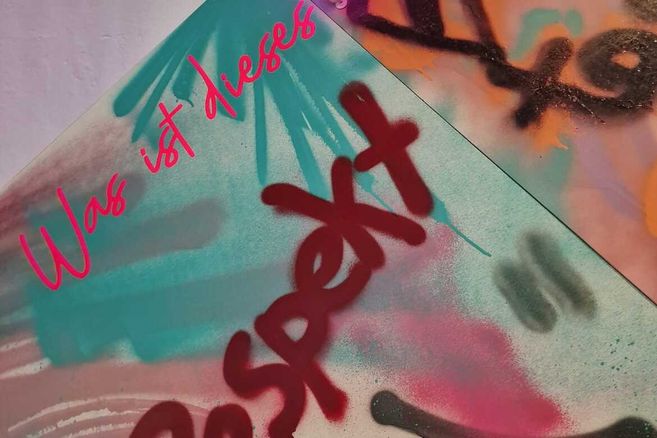 Graffiti mit den Worten 'Was ist dieses Respekt' in bunten Farben.