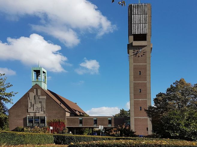 Außenansicht der Christus-Kirche mit Glockenturm und blauen Himmel.