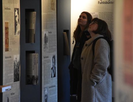 Zwei Menschen lesen Infotafeln in der Ausstellung