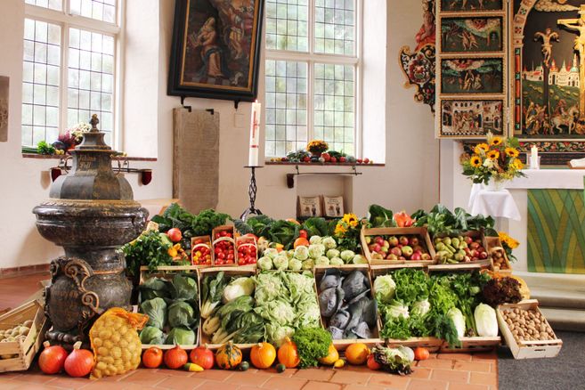 Erntedankfest in einer Kirche mit Gemüse und Obst dekoriert.